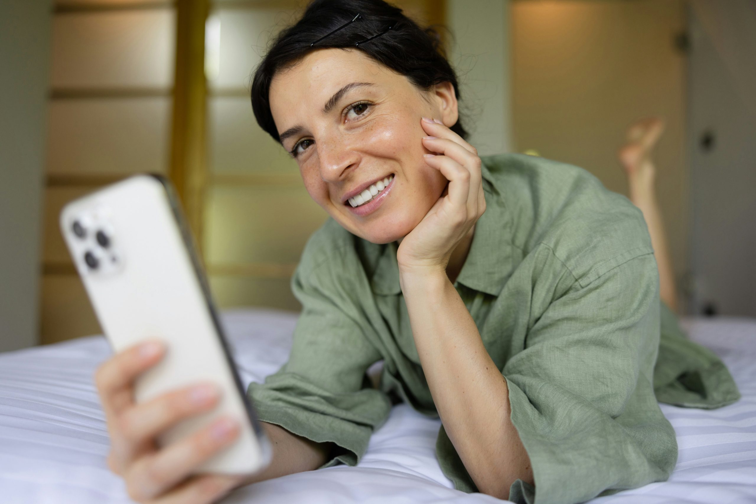 Image of a woman smiling while holding her phone displaying increased engagement metrics