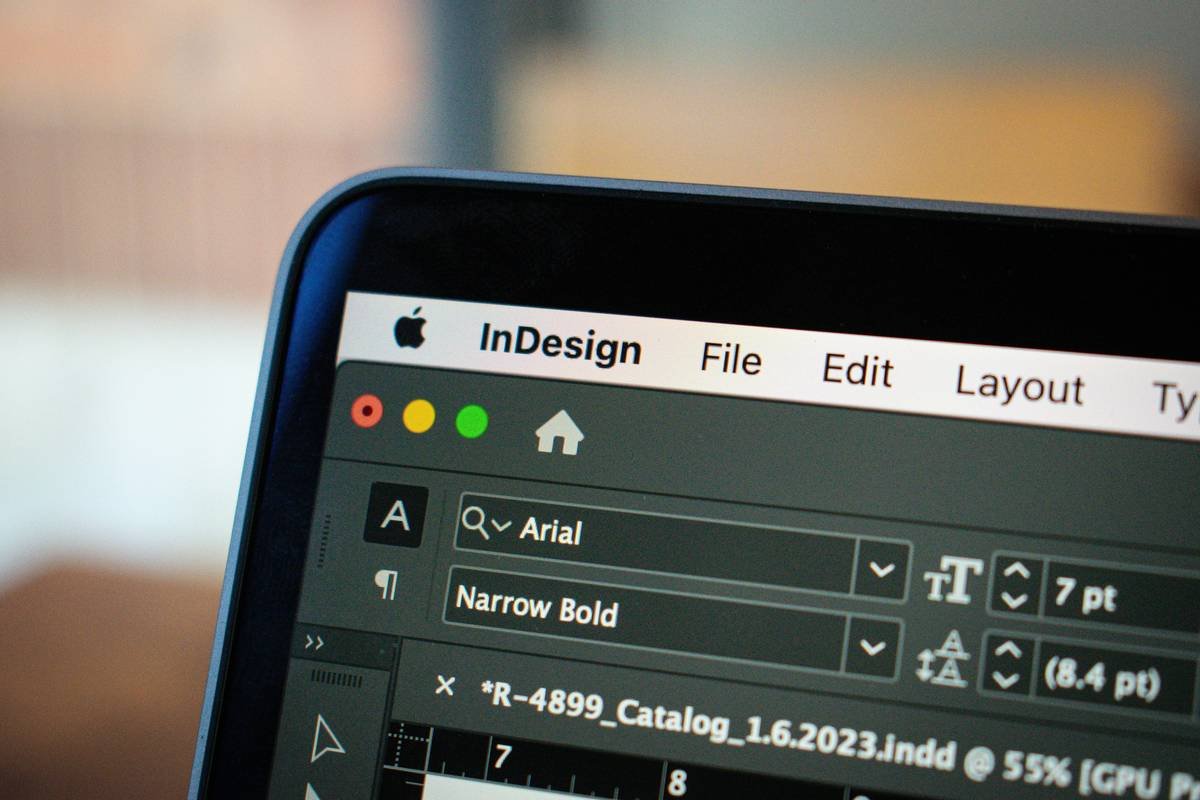 This close-up image showcases a MacBook Pro screen displaying an open project in Adobe InDesign. The focus is on the detailed interface of InDesign, with various design elements and toolbars visible, illustrating the software's functionality in graphic design and layout creation. The MacBook Pro's sleek design and high-resolution screen are highlighted, emphasizing the clarity and precision with which creative projects can be developed and viewed on this device.