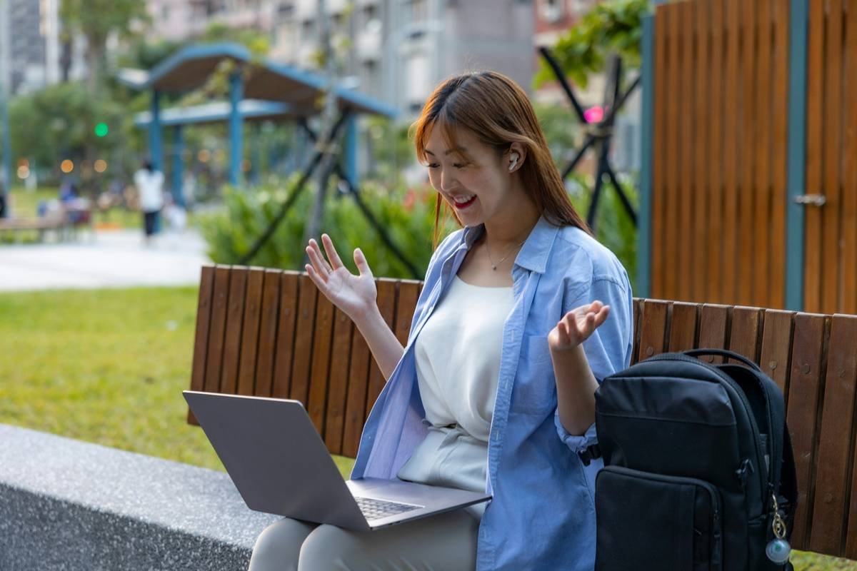 Young Woman Doing Remote Work Video Call at a Park Bench